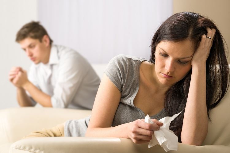 couple sitting in separate areas of the room to symbolize getting divorced